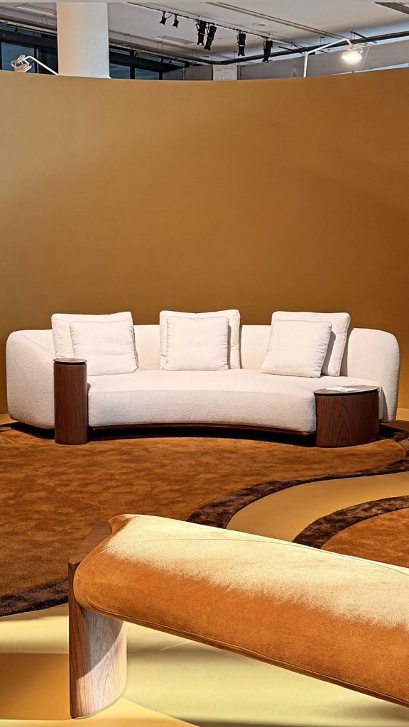 Modern Brazilian sofa design with organic rug and wooden side tables at SP-Arte